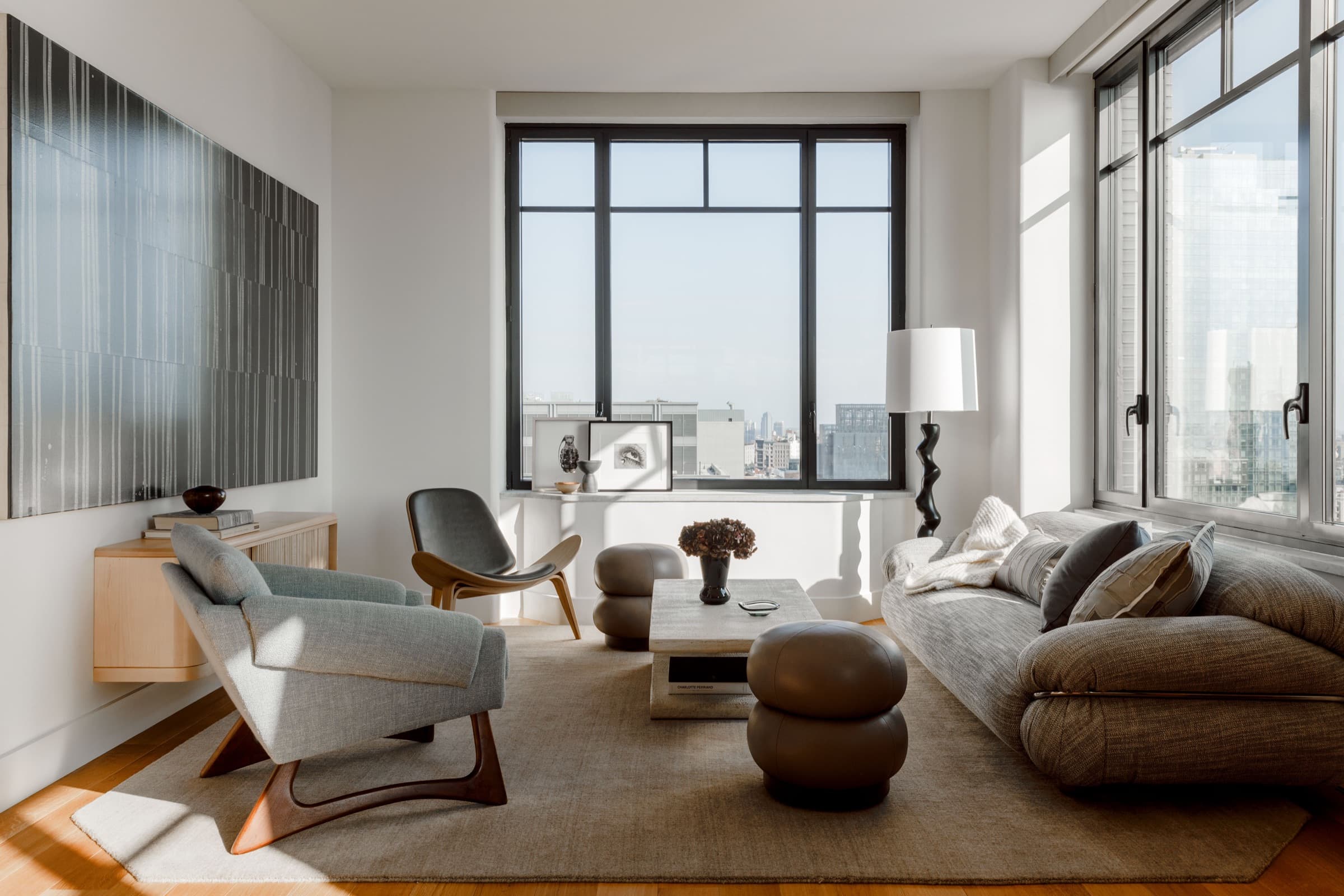 The living room is anchored by vintage forms, large-scale art, and downtown light.