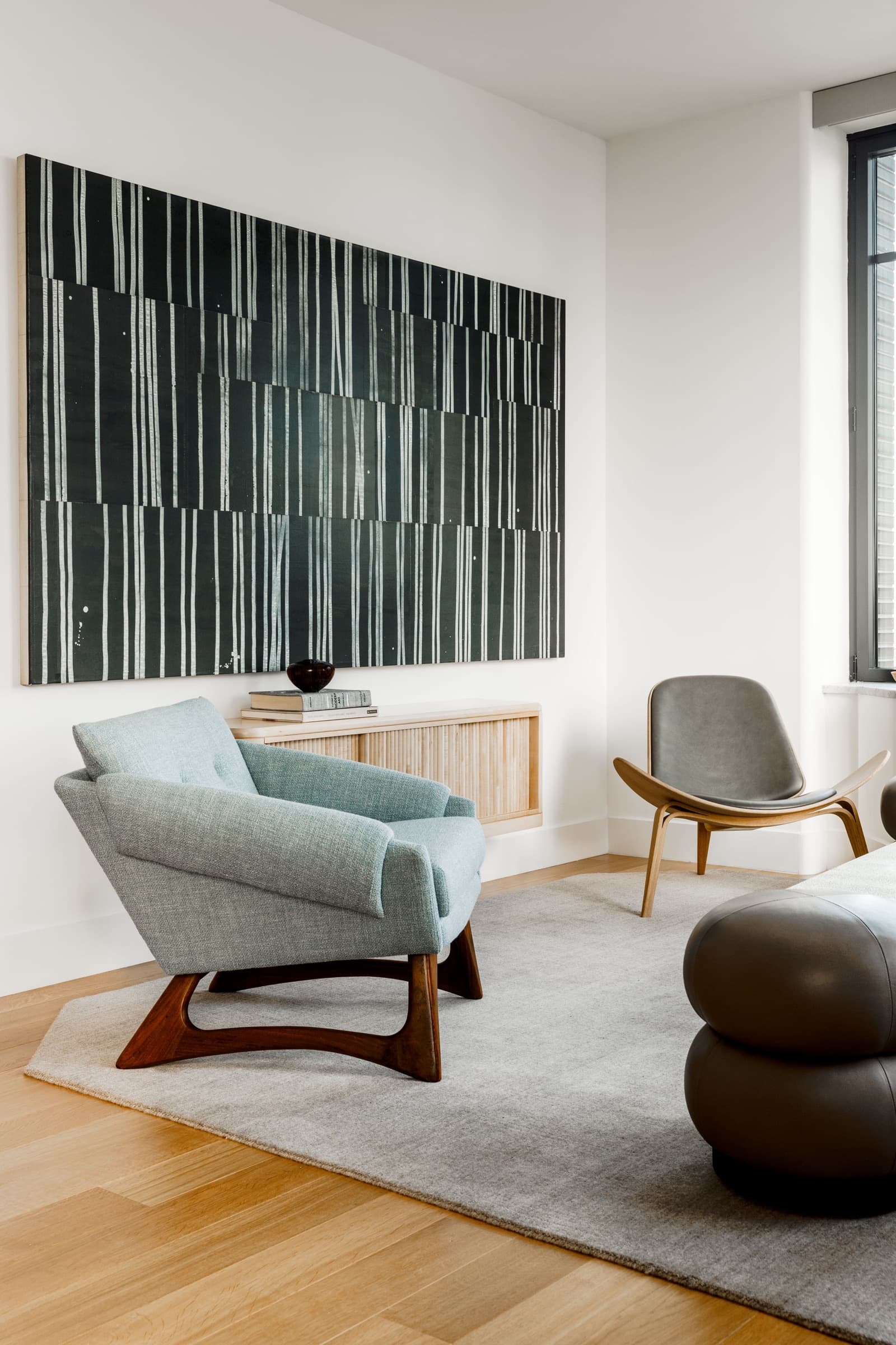 The bedroom introduces saturated art against a softened architectural envelope.