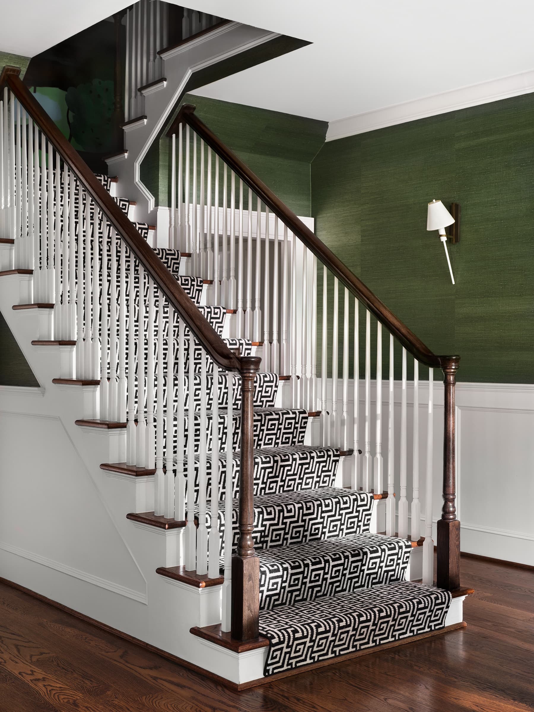 Woven shades and stone surfaces bring warmth to the architectural envelope.