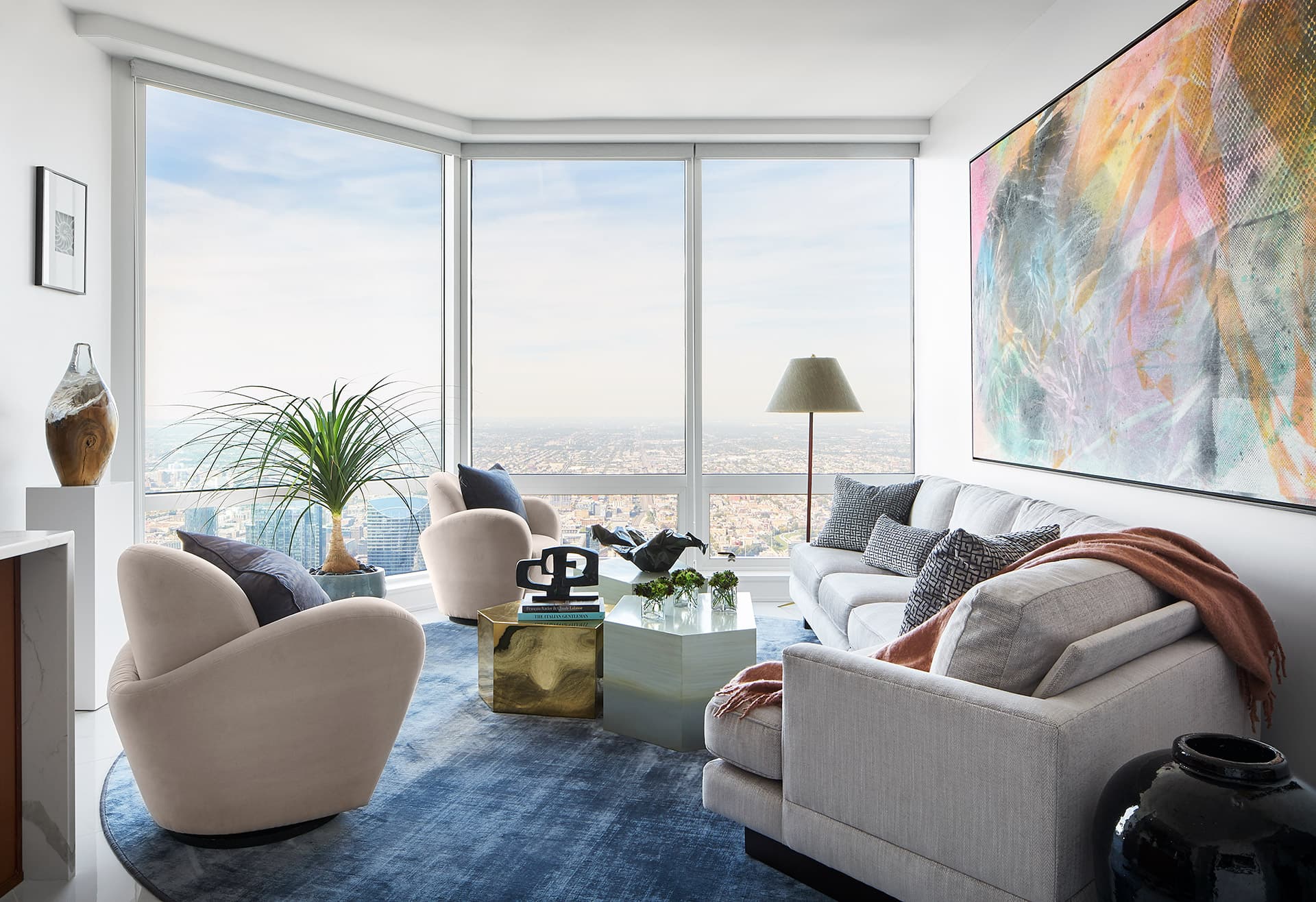 Curved seating and a saturated rug soften the penthouse perimeter.