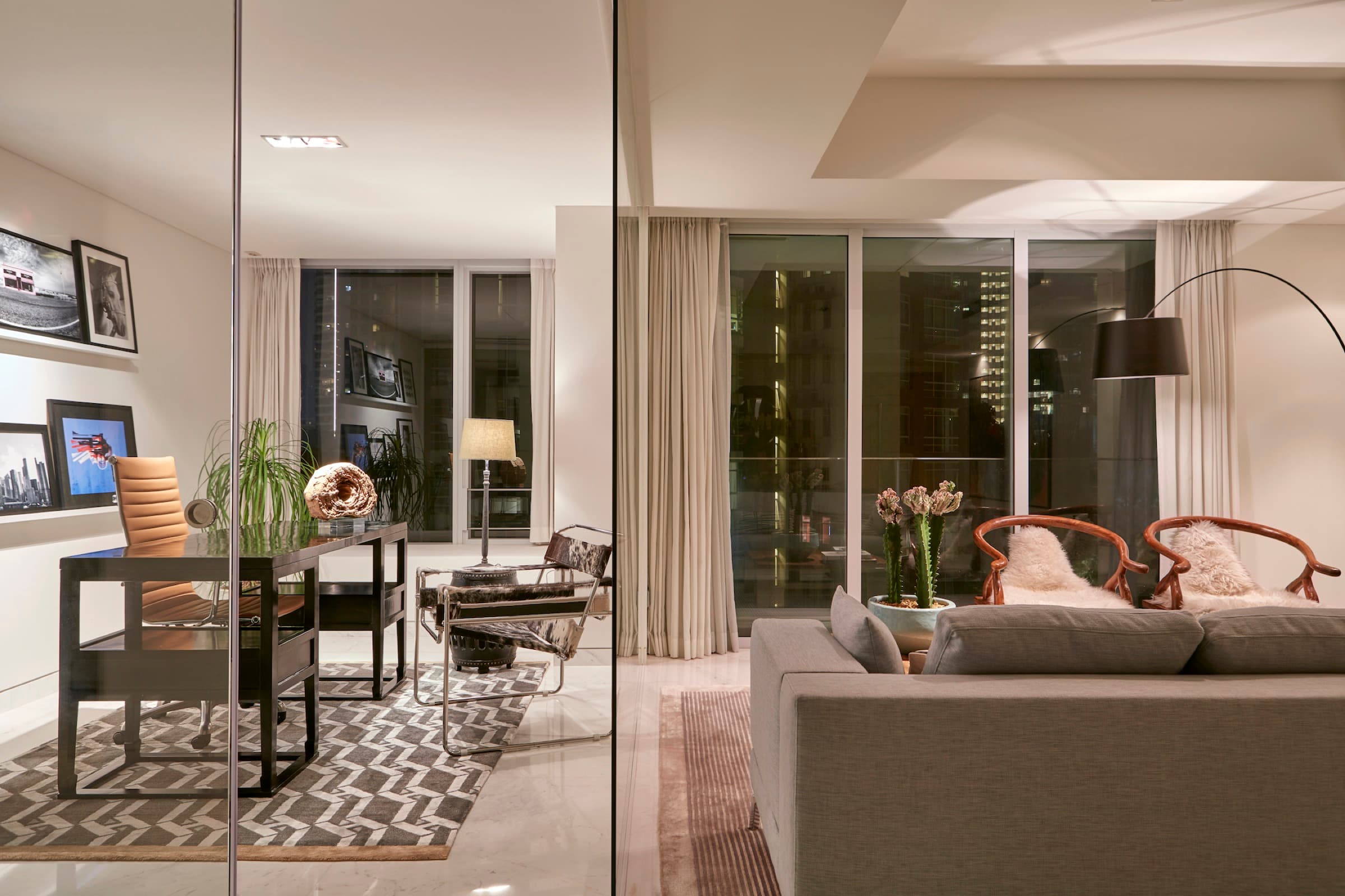 Glass, city views, and layered furnishings define the high-rise residence.