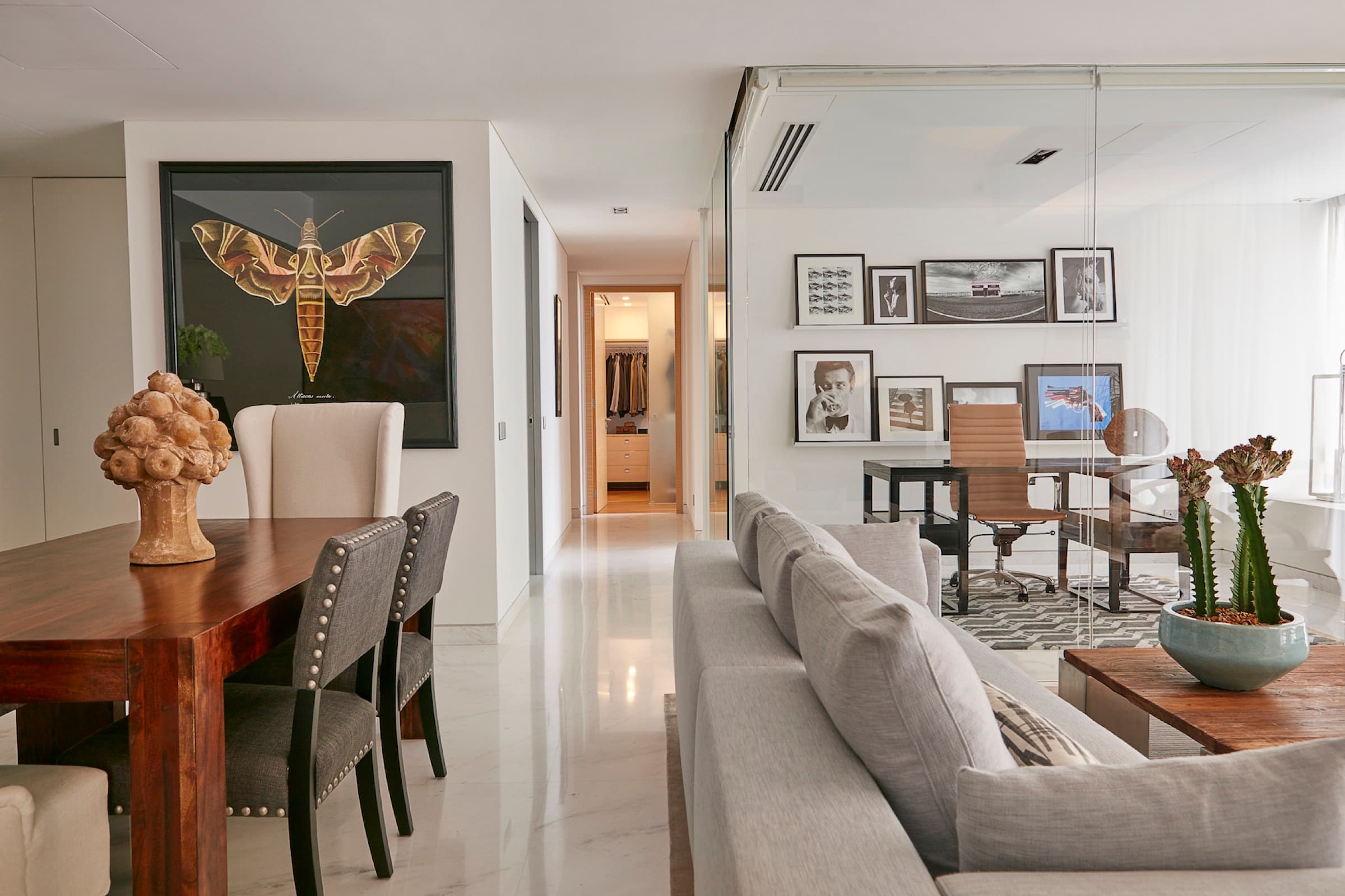 Glass, city views, and layered furnishings define the high-rise residence.