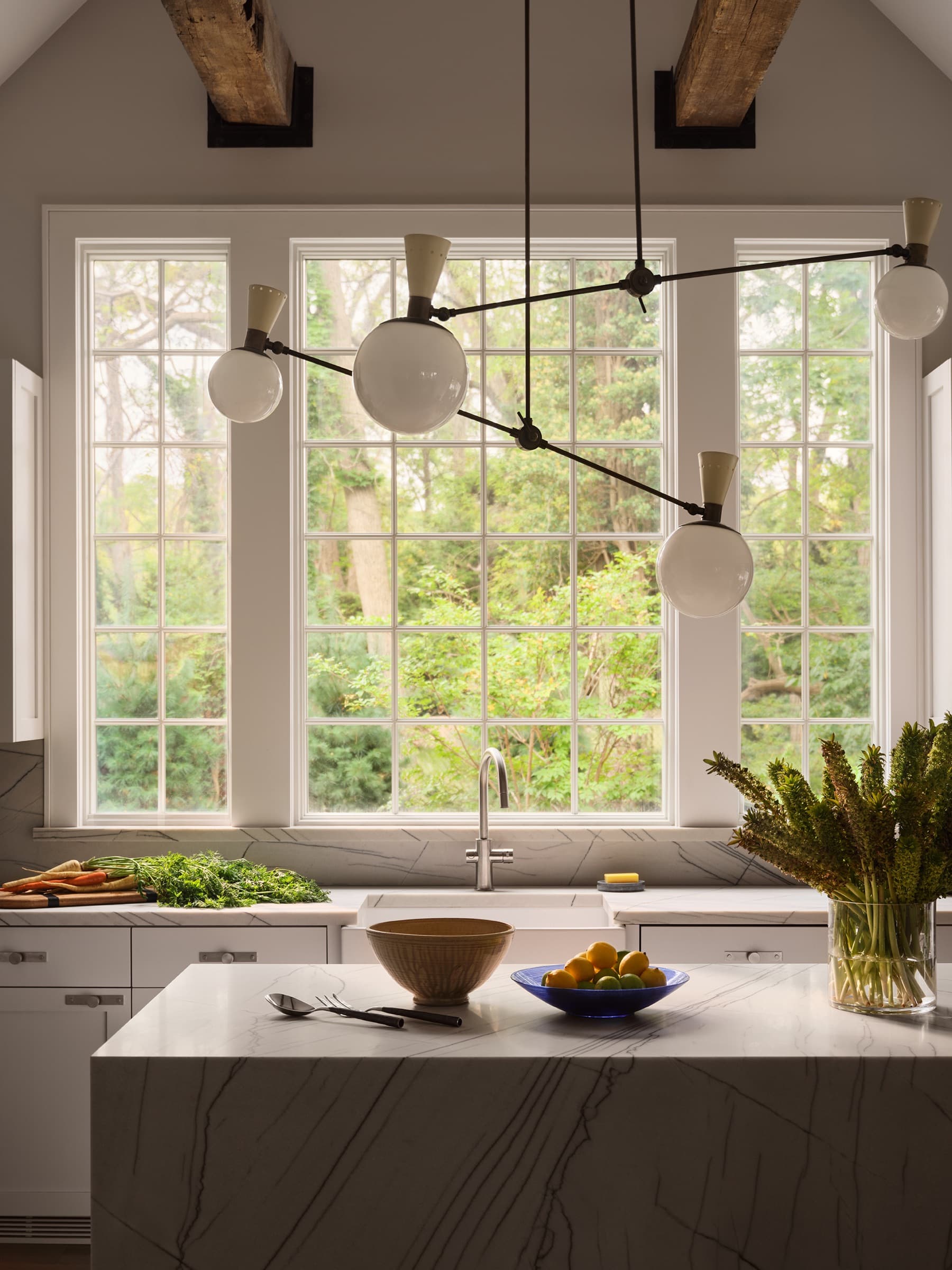 A framed view into the dining room balances tailored architecture, expressive art, and living materials.