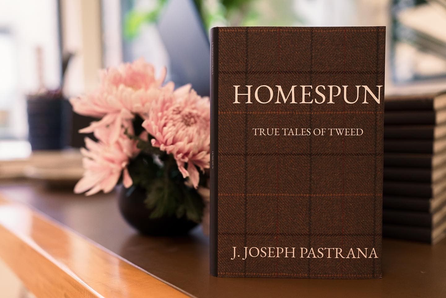 Homespun: True Tales of Tweed book photographed with pink flowers