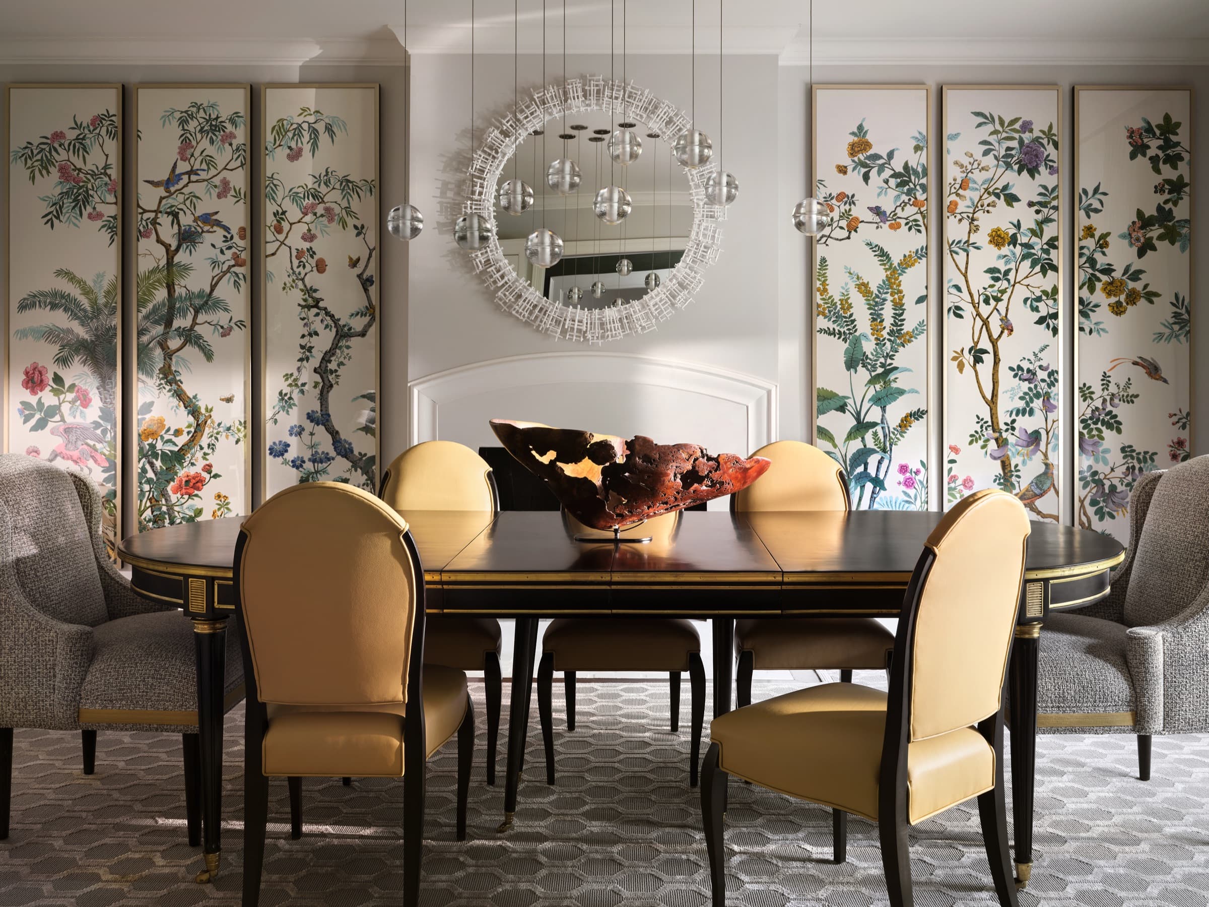 Houston dining room with botanical panels, a sculptural mirror, suspended glass lighting, and tailored seating